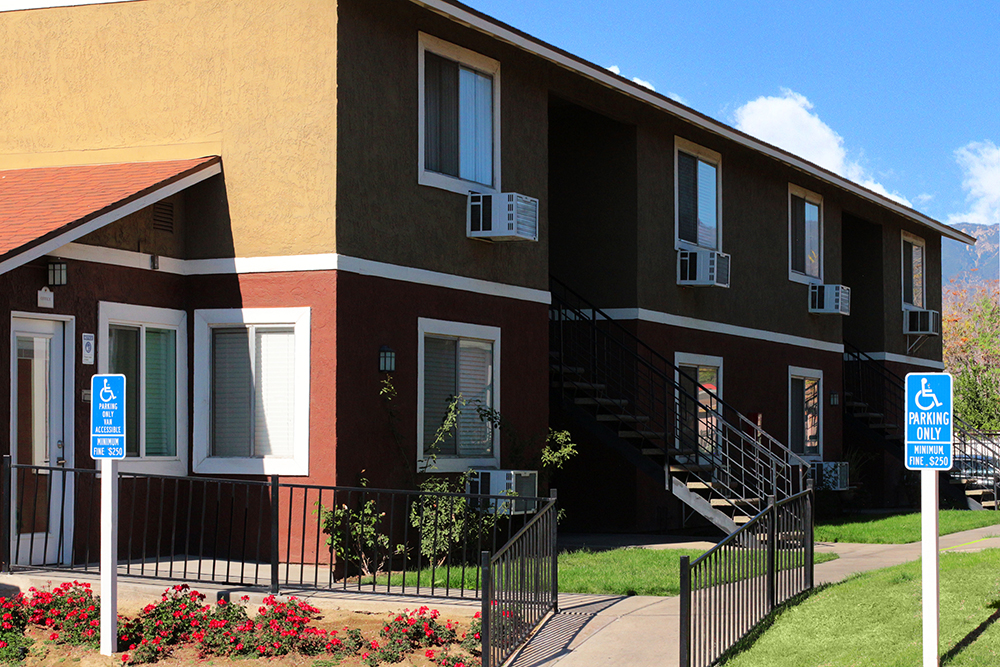 This image displays two-story building photo of Villa De La Rosa Apartments